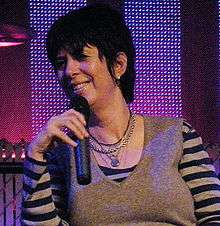 Diane Warren holding a mic.