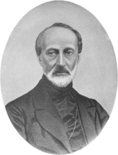 Black-and-white half-length portrait of a thin, angular balding man