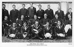 A group of 19 men arranged in three rows, many of them in naval uniforms