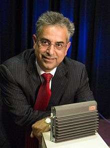 A portrait of Rouzbeh Yassini pose with original LANcity modem-