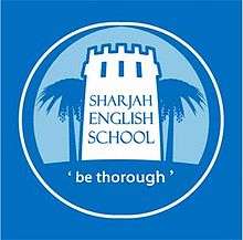 SES Emblem. Tower surrounded by palm trees, displaying name & slogan.