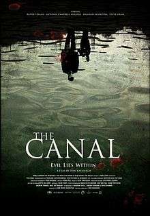A film poster showing the reflection of man and a young boy in the water. At the bottom of the poster, the tag line says, "Evil lies within".