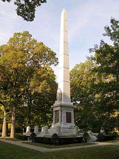 White monumental obelisk in the trees