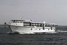a white ferry boat sails across dark blue waters